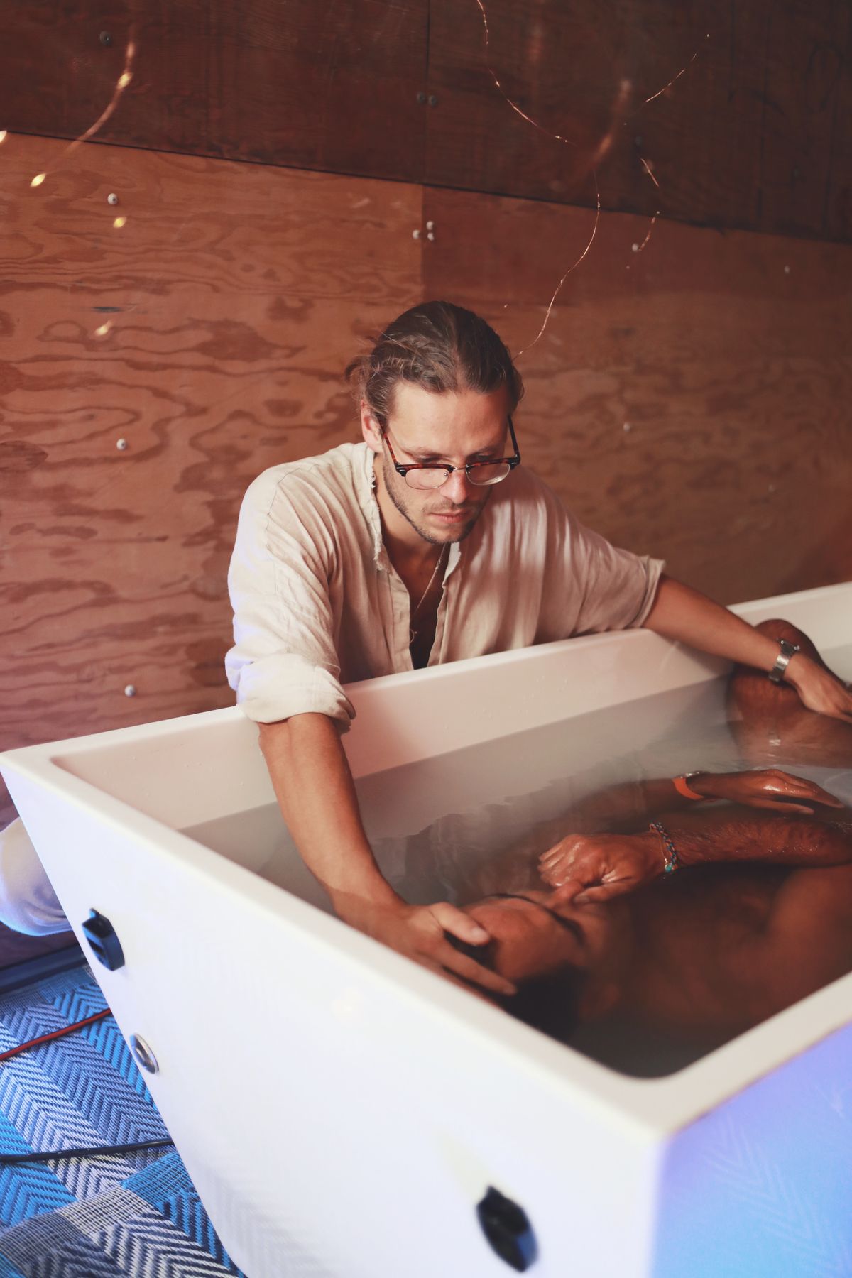 David guiding a person through an ice bath at Burning Man 2023