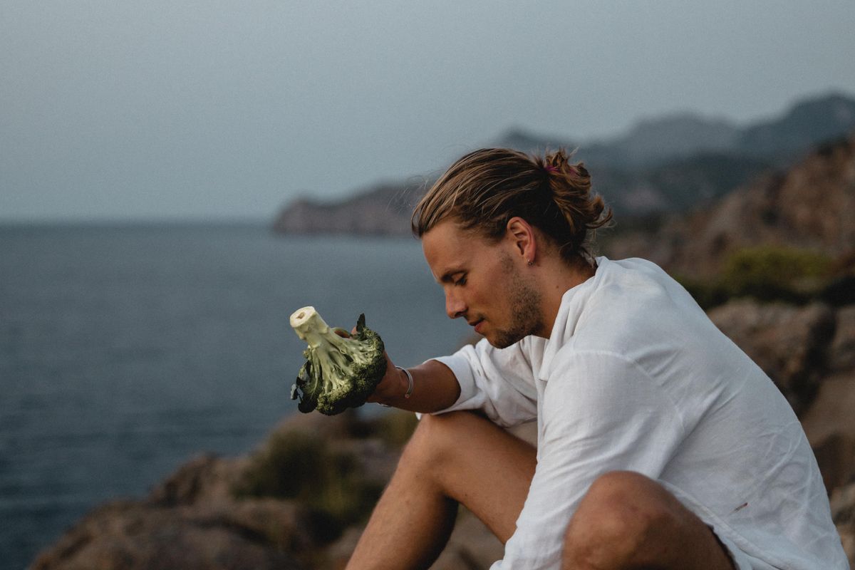 David holding broccoli on coastal rocks, 2021